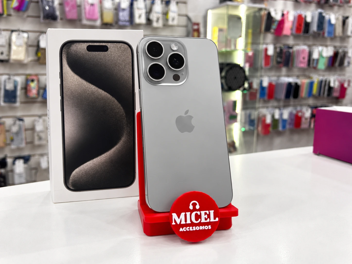Imagen ilustrativa de iPhone Pro plateado en soporte rojo MICEL.